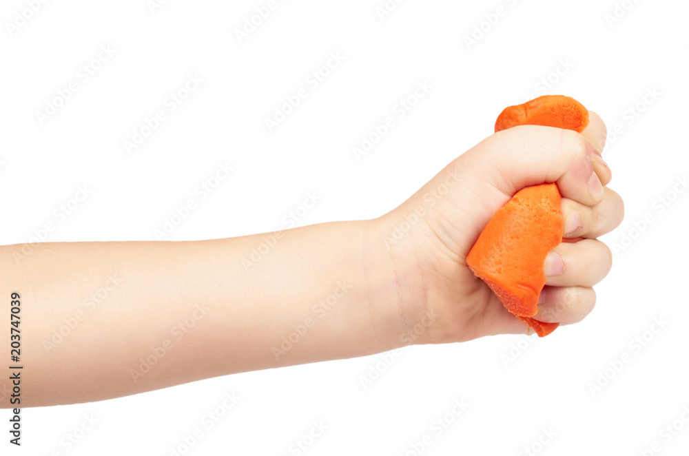 Orange plasticine bar with kid hand, isolated on white background Orange plasticine bar with kid hand, isolated on white background