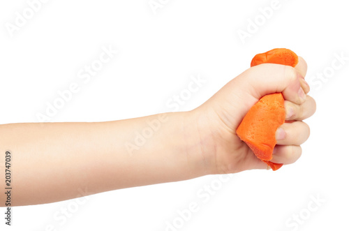 Orange plasticine bar with kid hand, isolated on white background photo