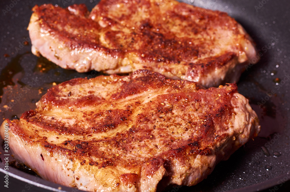 grilled meat steak with spices on fying pan