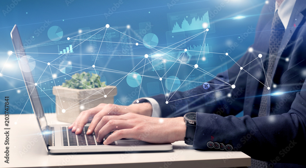 Businessman typing on laptop with linked reports charts grapghs around
Businessman typing on laptop with linked reports charts grapghs around