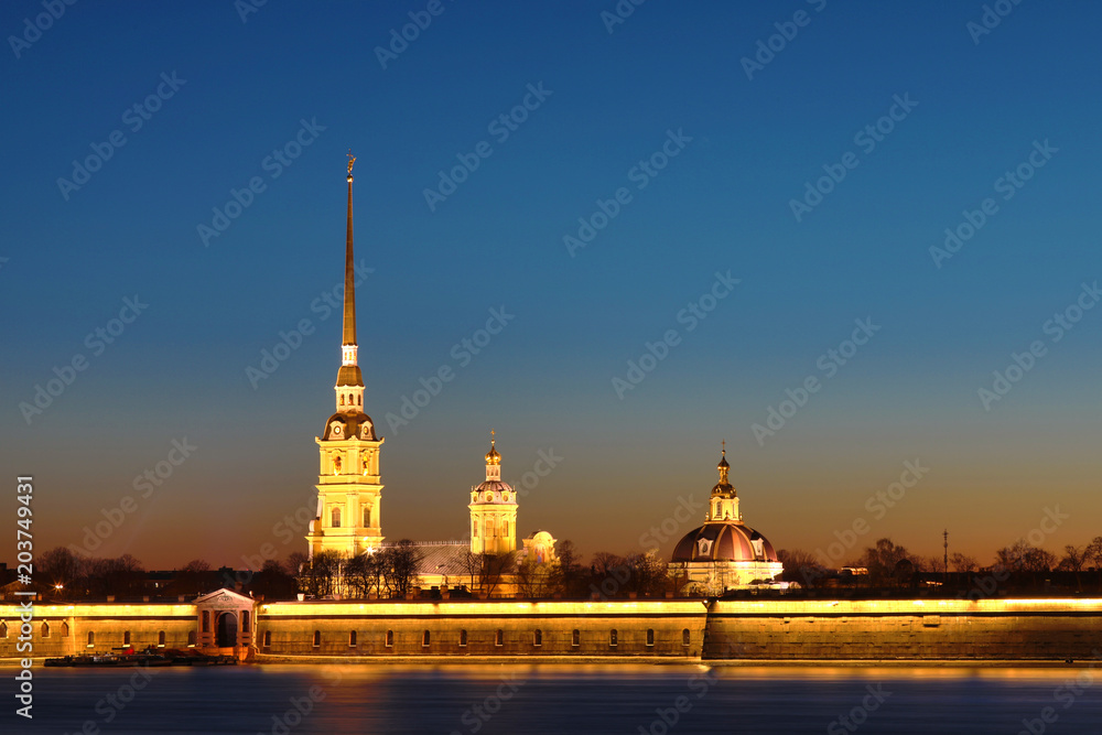 Peter and Paul Fortress of St. Petersburg, Russia in the rays of setting sun. The Peter and Paul Fortress is the original citadel founded by Peter the Great in 1703 and built to Trezzini's designs Peter and Paul Fortress of St. Petersburg, Russia in the rays of setting sun. The Peter and Paul Fortress is the original citadel founded by Peter the Great in 1703 and built to Trezzini's designs