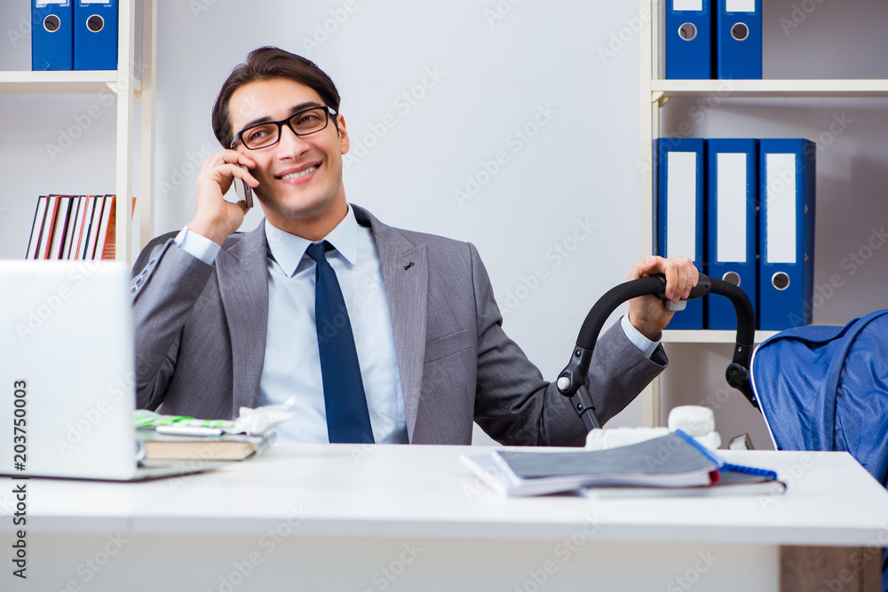 Businessman looking after newborn baby in office