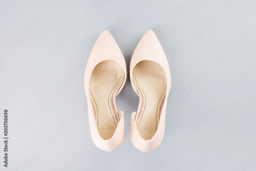 Pale pink female shoes close up on gray background. Pale pink female shoes close up on gray background.