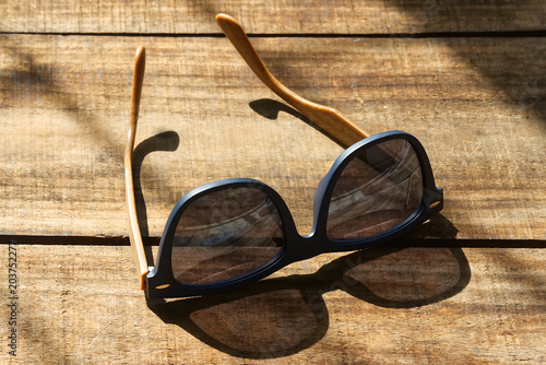 Sunglasses on the wooden table in the morning