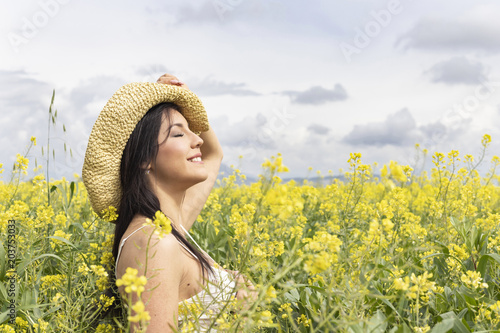 Mujer feliz en el campo de flores de jaramagos