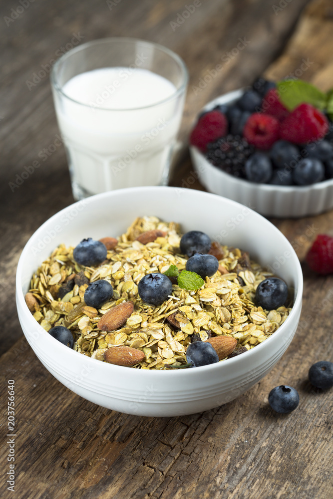 Homemade granola with fresh berries and mint, served with milk Homemade granola with fresh berries and mint, served with milk