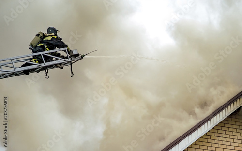 A firefighter puts out a burning building with height extension ladders