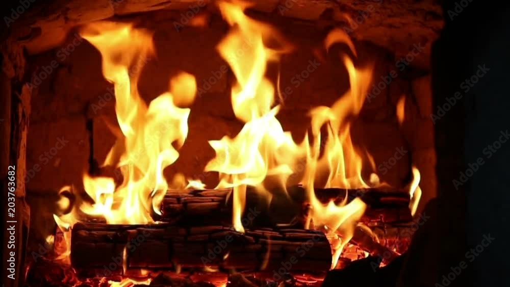 Firewood and fire flames in fireplace, bonfire close-up. Firewood and fire flames in fireplace, bonfire close-up.