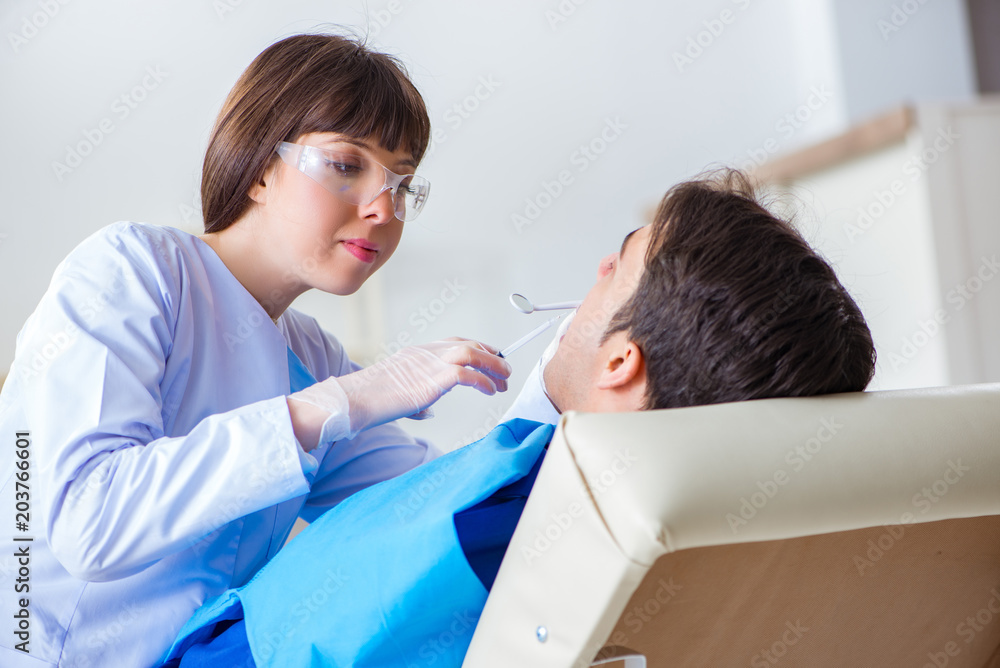 Obraz premium Woman dentist doctor with male patient in hospital
