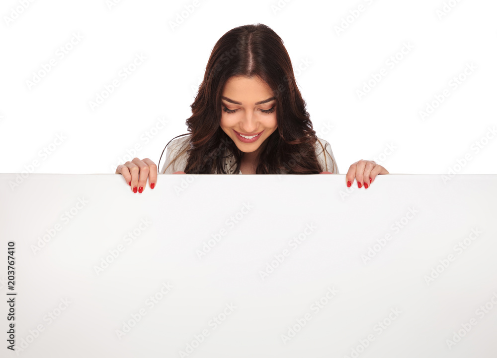portrait of smiling businesswoman looking down at empty billboard portrait of smiling businesswoman looking down at empty billboard