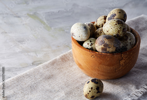 Bowl with eggs quail  eggs on a homespun napkin on grey background  close-up  selective focus