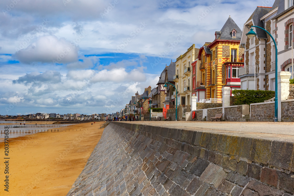 High stone embankment and beach at low tide, in beautiful walled port city of Privateers Saint-Malo, also known as city corsaire, Brittany, France