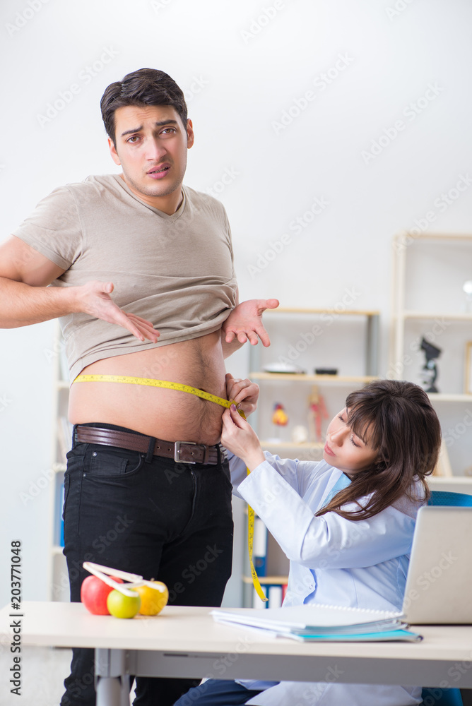 Obraz premium Doctor dietician giving advices to fat overweight patient