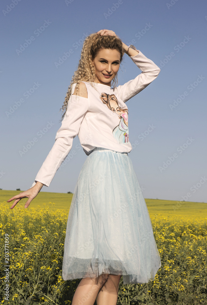 Cute posing and smiling model in romantic dress posing in countryside background. Cute posing and smiling model in romantic dress posing in countryside background.