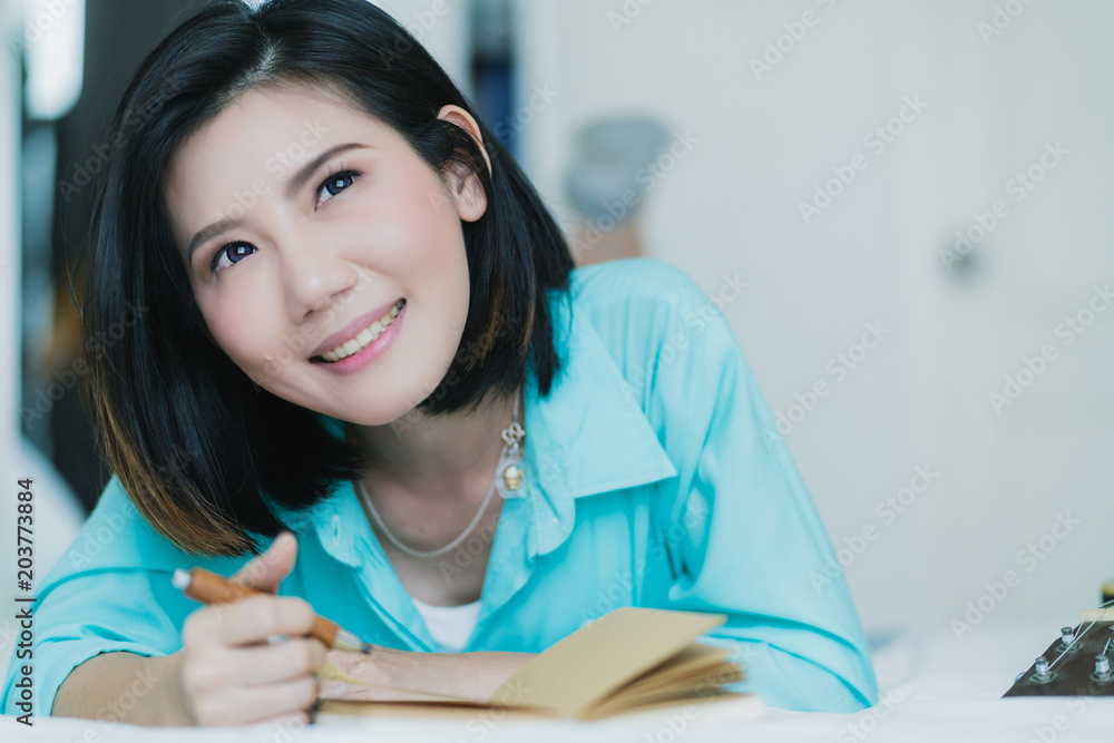 traveller asian tourist with notebook and pencil writing story of vacation near curtain window light with happiness and emotional traveller asian tourist with notebook and pencil writing story of vacation near curtain window light with happiness and emotional