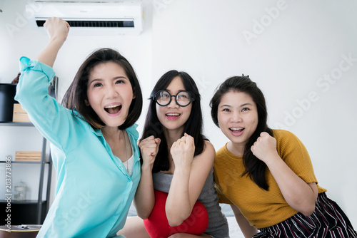 Group of asian woman friends having fun at sofa home,watching game sport programe and enjoying together.