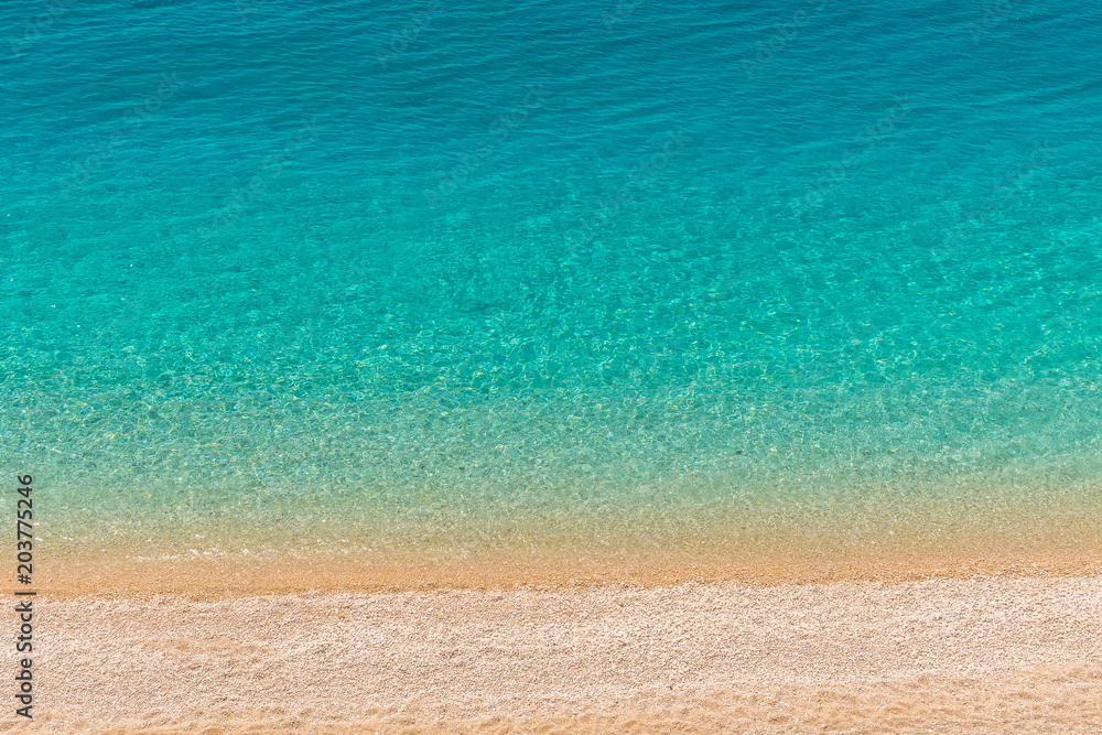 Obraz premium Crystal clear turquoise sea waters of a pebble beach. Porto Katsiki beach in Lefkada ionian island in Greece. 