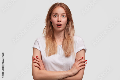 Beautiful young European terrfied female with shocked expression, wears casua...