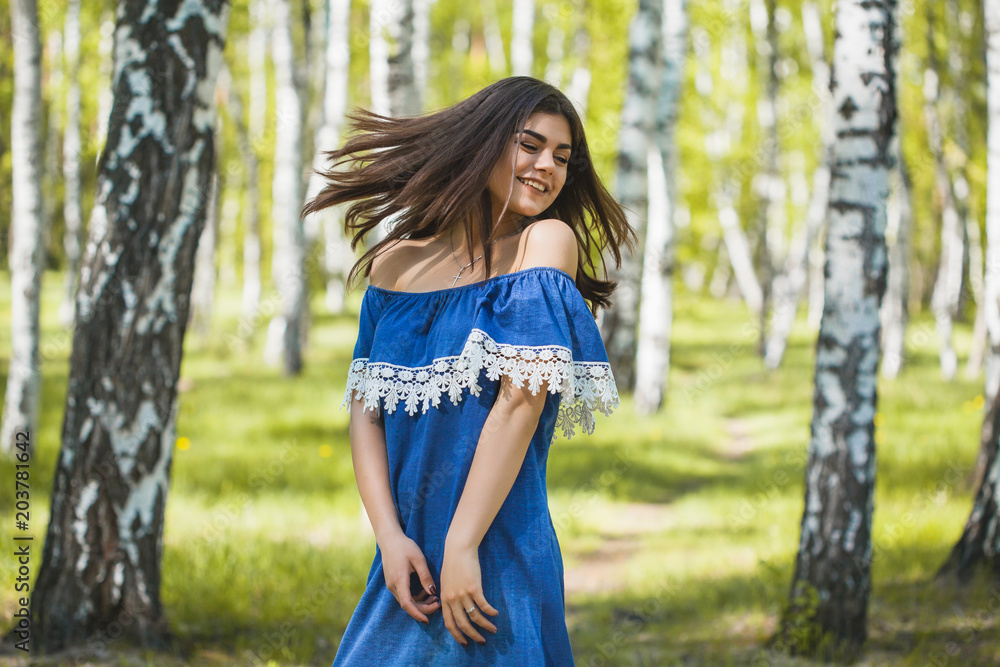 Beautiful young woman is walking in the park at sunset Beautiful young woman is walking in the park at sunset