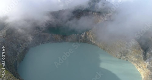 Kelimutu tri coloured volcano crater covered with mist an aerial view early morning, Indonesia photo