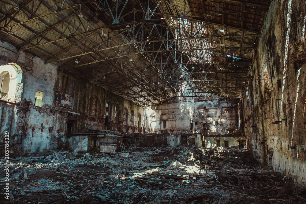 Ruins of industrial building interior after disaster or war or earthquake, inside huge warehouse, pills of rubbish