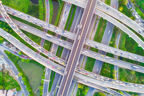 Aerial view car movement on traffic junction road with green tree park