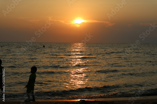 silhouette one kid play on sea sunset