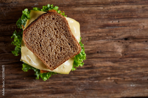 Tasty and fresh sandwiches on a dark wooden table, close-up