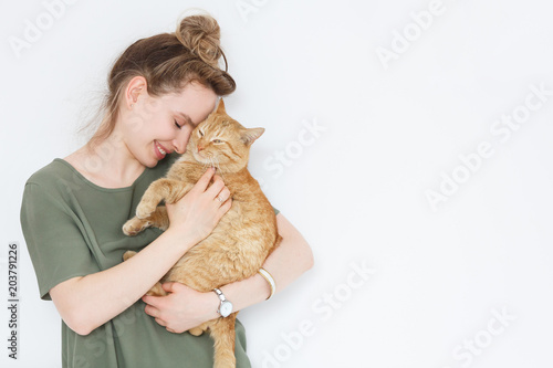 Canvas-taulu Closeup portrait handsome young hipster woman, hugs his good friend ginger cat on white wall background