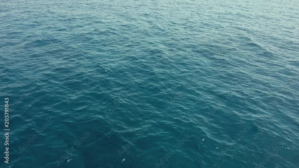 A Wake From a Ship at Sea with Blue Ocean Water, a Horizon, Blue Sky and Clouds. A Wake From a Ship at Sea with Blue Ocean Water, a Horizon, Blue Sky and Clouds.