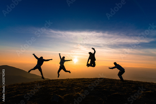 silhouette of friends jumping in sunset for happiness,fun and team work concept