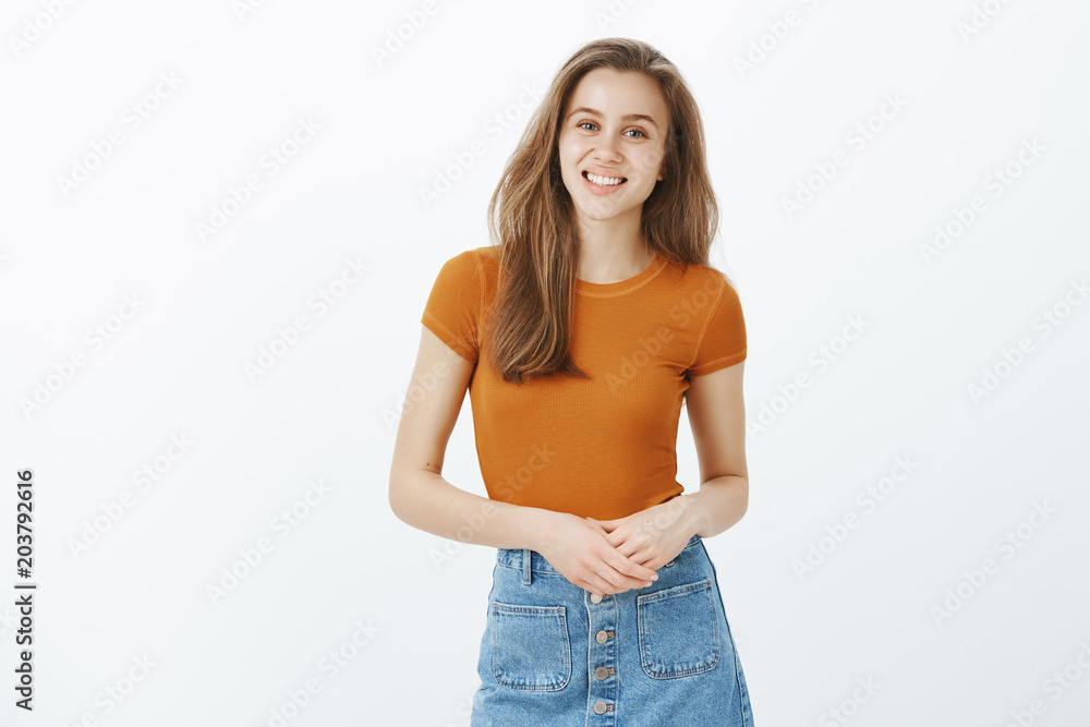 How can I help you. Timid unconfident good-looking european girl in stylish outfit, touching hands over chest and smiling politely while talking with customers and offer help in choosing goods How can I help you. Timid unconfident good-looking european girl in stylish outfit, touching hands over chest and smiling politely while talking with customers and offer help in choosing goods