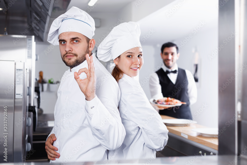 Portrait of team of professional restaurant cooks in kitchen
