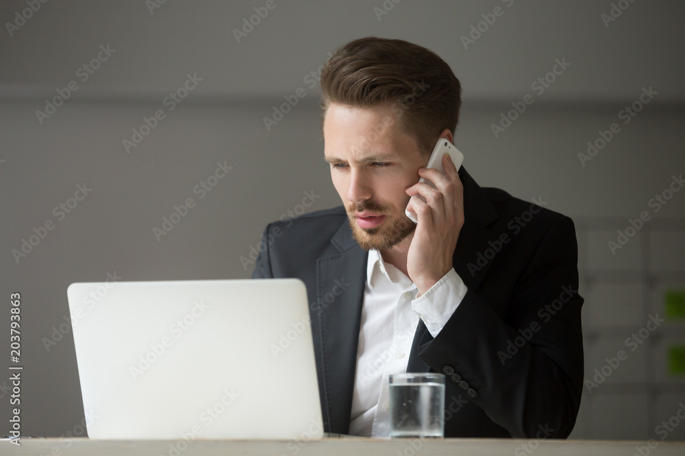 Concentrated worried male CEO talking on cell phone discussing financial crisis and solving company business problems. Concept of financial collapse and failure, trader negotiating Concentrated worried male CEO talking on cell phone discussing financial crisis and solving company business problems. Concept of financial collapse and failure, trader negotiating