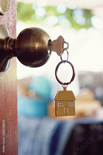 House key with home keyring in keyhole, property concept