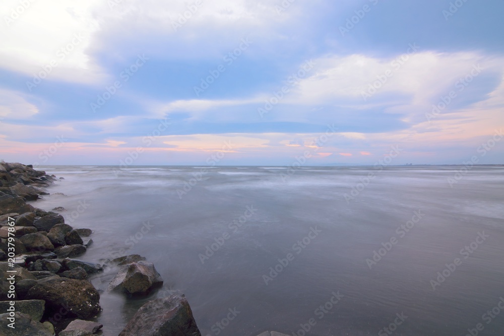 Dusk Landscape of sea waves hitting the island in long exposure setting