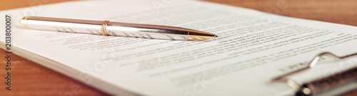 Pen lying on a contract or application form, wide angle view.