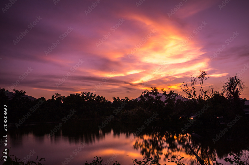 Obraz premium Sunset glow in the sky with reflection from the lake. Amazing natural drawing a beautiful picture in the sky.