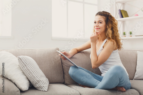 Young redhead girl with digital tablet at home