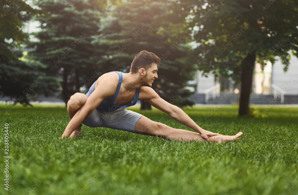 Fitness man at stretching training outdoors