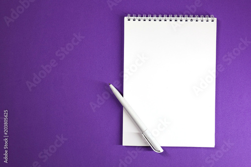 Notepad and pen on colored background top view, school, business, education