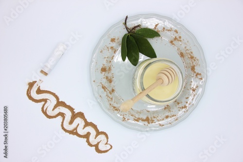 Home made lip balm with beeswax, cocoa and sage. White background