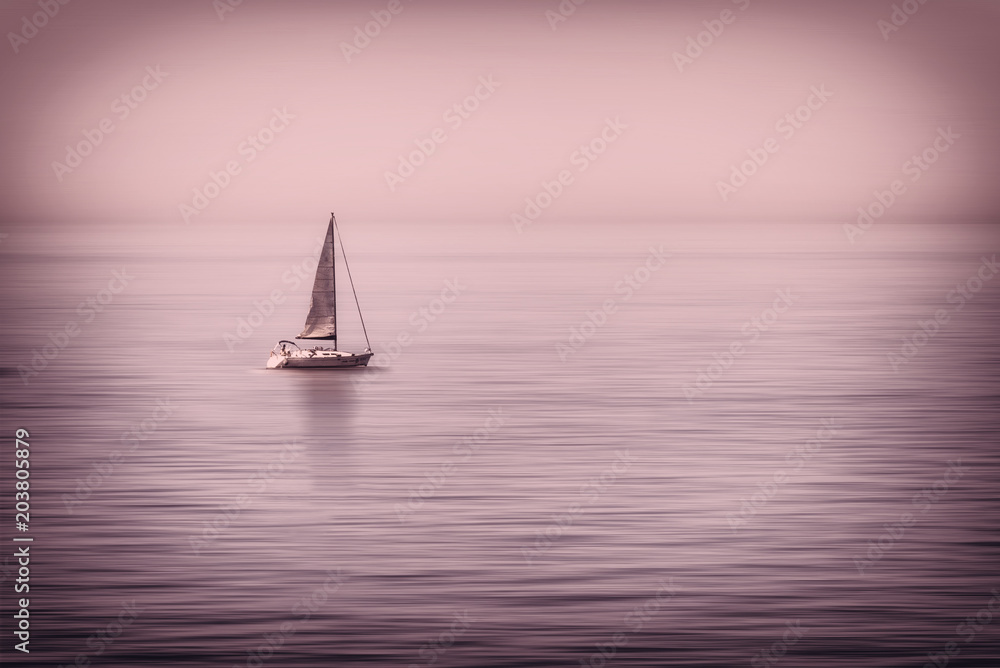 Astratto di  barca a vela solitaria in mezzo al mare calmo