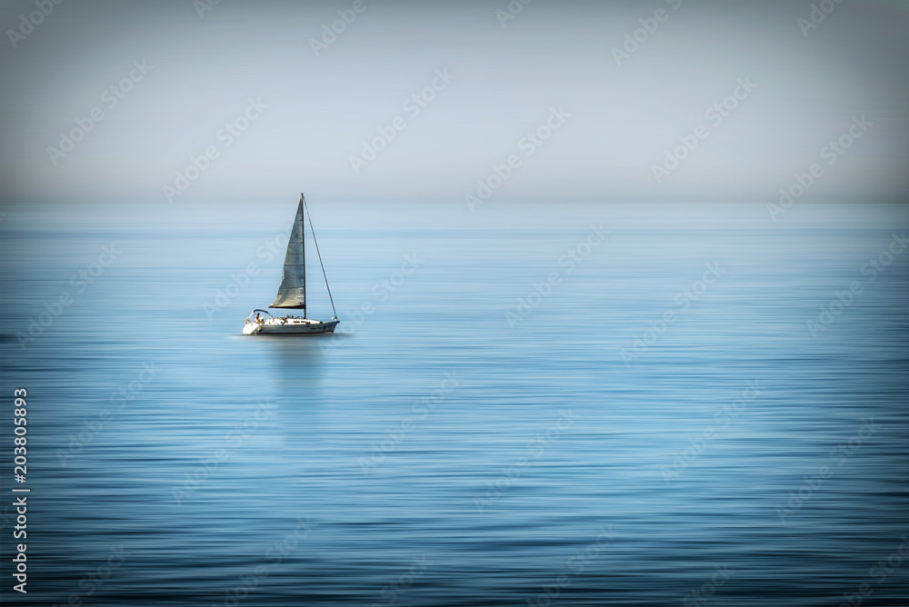 Astratto di  barca a vela solitaria in mezzo al mare calmo