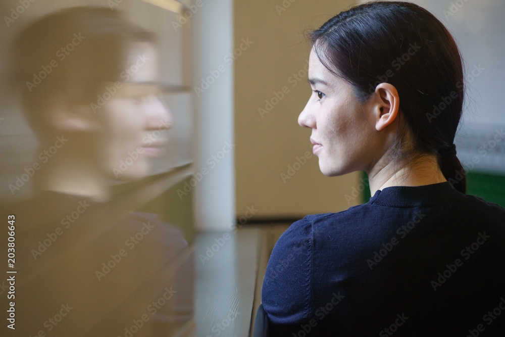 Indoor portrait of young beautiful model of mixed race dressed in black dress standing at the corridor with green tiles Indoor portrait of young beautiful model of mixed race dressed in black dress standing at the corridor with green tiles