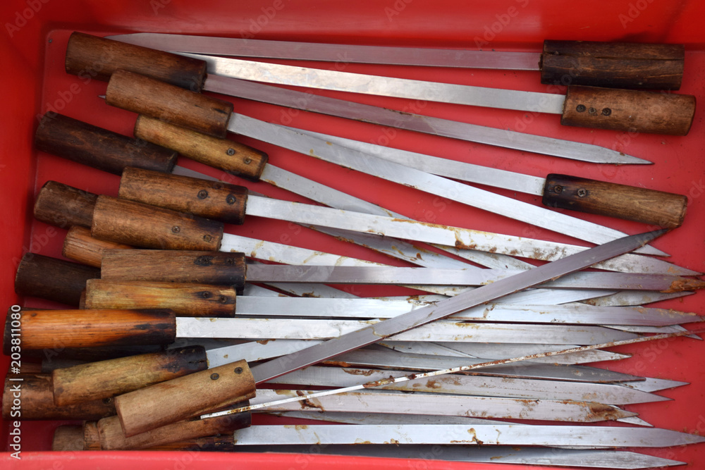 Fototapeta premium metal skewers with wooden handle in a red box after the barbecue