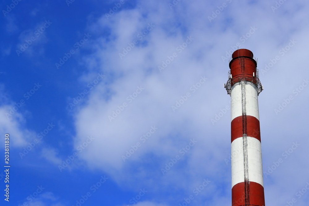 Boiler pipe with red and white stripes against on a blue sky with clouds. Boiler pipe with red and white stripes against on a blue sky with clouds.