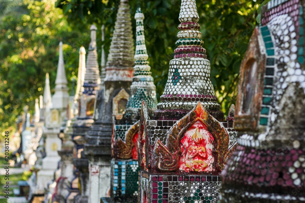 Fototapeta premium Row of buddhist temple mini stupas of different designs in the island of Koh Phangan, Thailand