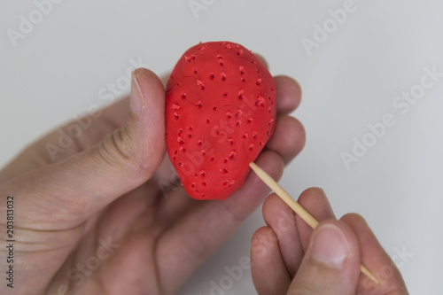 step by step making strawberry with play dough on the white background for children's activity in school.