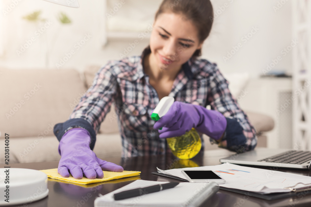 Woman using spray cleaner on wooden surface Woman using spray cleaner on wooden surface